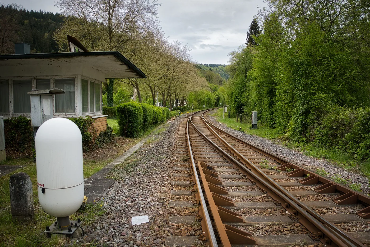 A weatherproof equipment cabinet standing beside a railway line in the open air.
