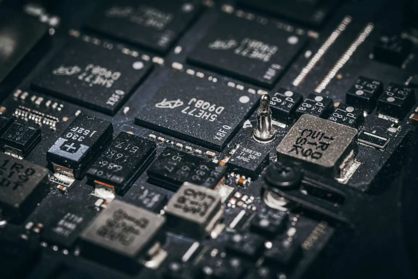 Close-up of a bare single-board computer showing surface-mount components, a heatsinked processor, header pins and copper traces.