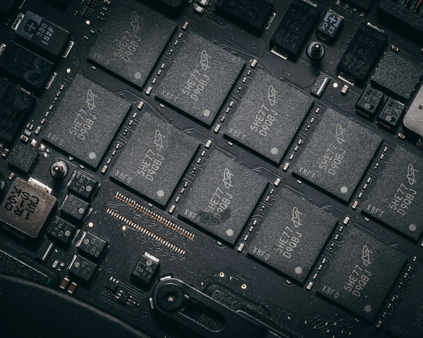 Close-up of a populated printed circuit board under bench lighting.