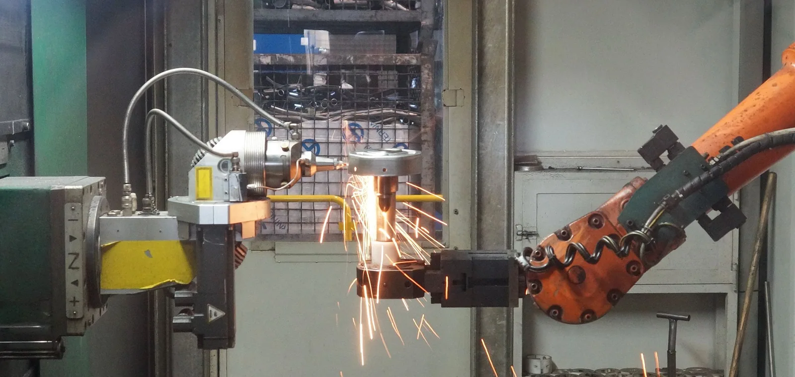 Industrial welding robot throwing sparks on a production line.