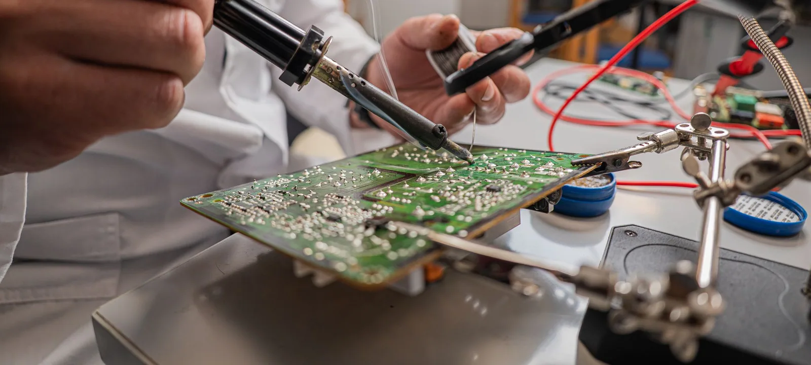 Engineer soldering components onto a circuit board.